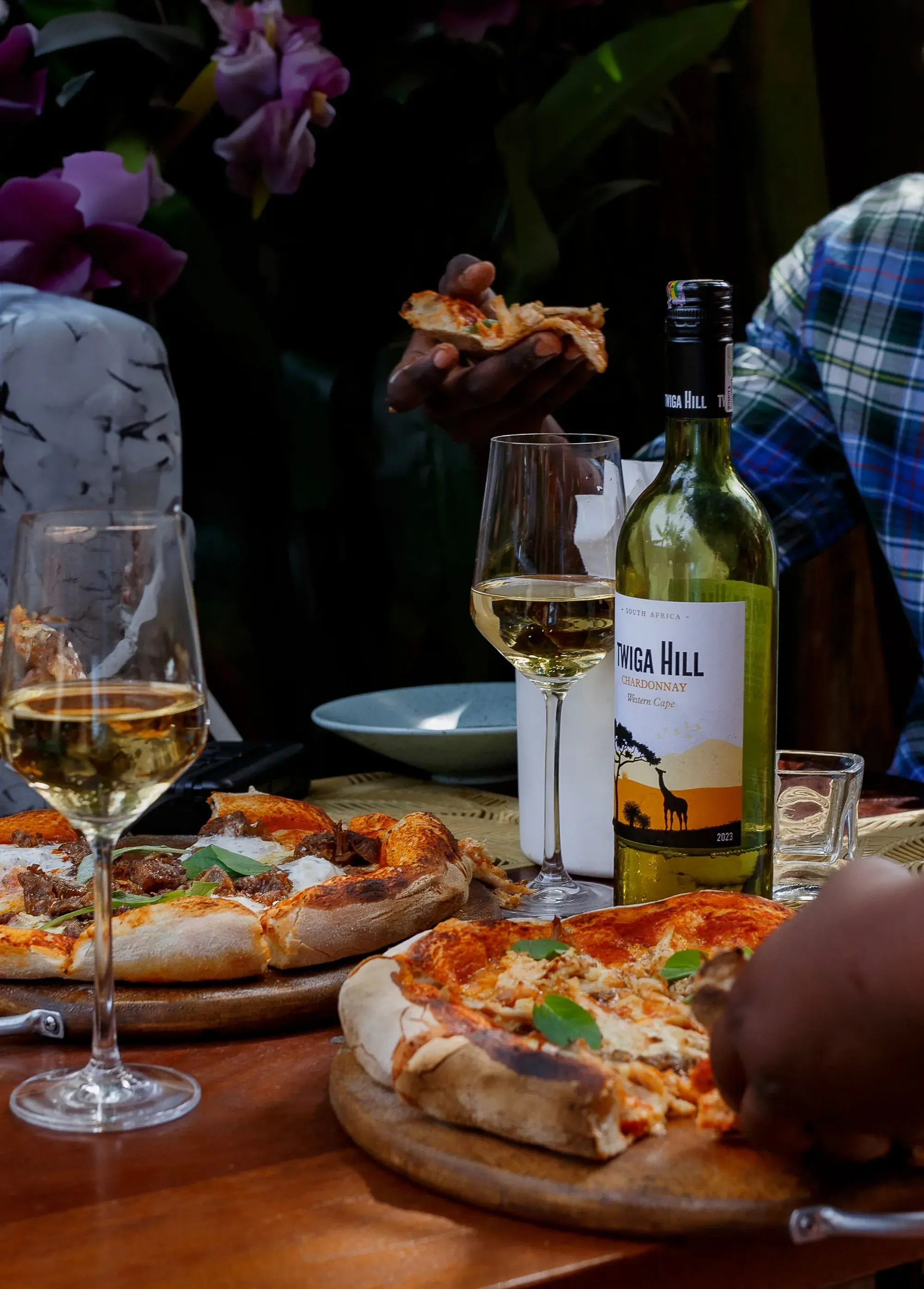 Pizzas et vin blanc partagés à une table du restaurant de GUEF HOTEL